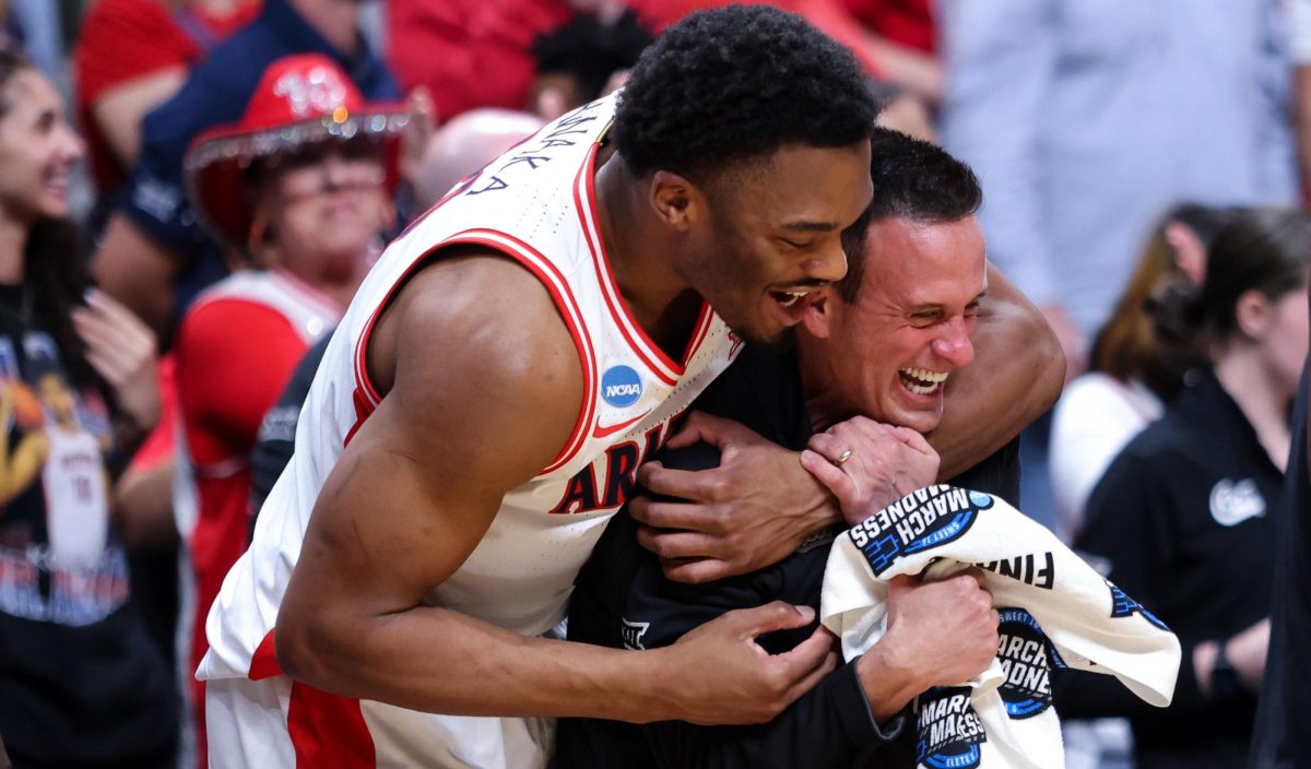 Tobe Awaka (30) tackles athletic trainer Justin Kokoskie after the Wildcats punch their ticket to the Final Four by beating the Purdue Boilermakers in the Elite Eight round of March Madness on March 28 in SAP Center in San Jose.
