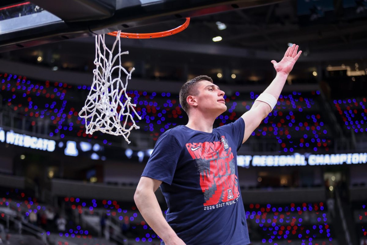 Ivan Kharchenkov hypes the crowd up as he cuts the championship net after winning the Elite Eight round of March Madness over Purdue University in SAP Center on March 28 in San Jose.