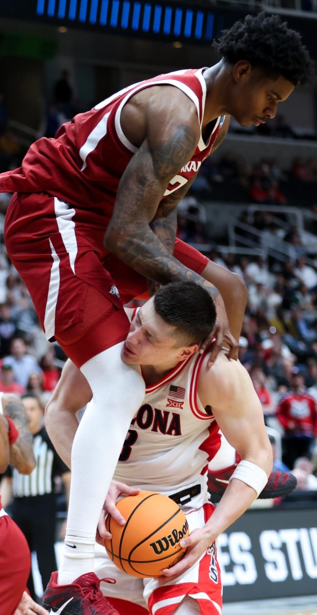 An Arkansas player lands on top of Ivan Karchenkov (8) as he fails to block his shot under the basket in SAP Center on March 26 in San Jose.