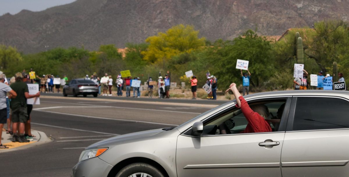 A passerby shows displeasure with ‘No Kings Day’ protesters on Kinney Road at Tucson Estates on March 28.