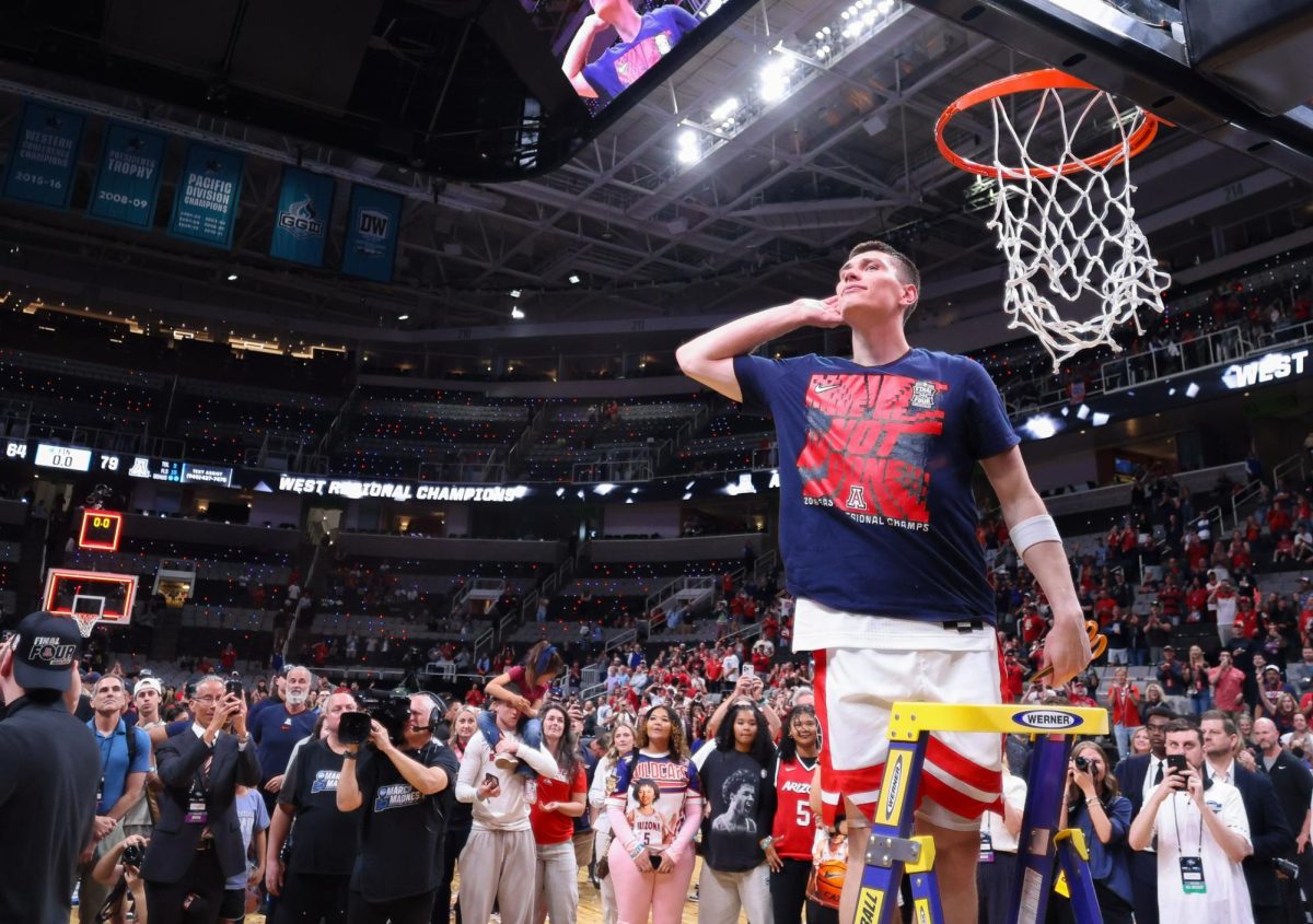 Ivan Kharchenkov still eggs on the crowd while cutting down the net after Arizona moved onto the Final Four with a victory against Purdue University on March 28 in SAP Center.