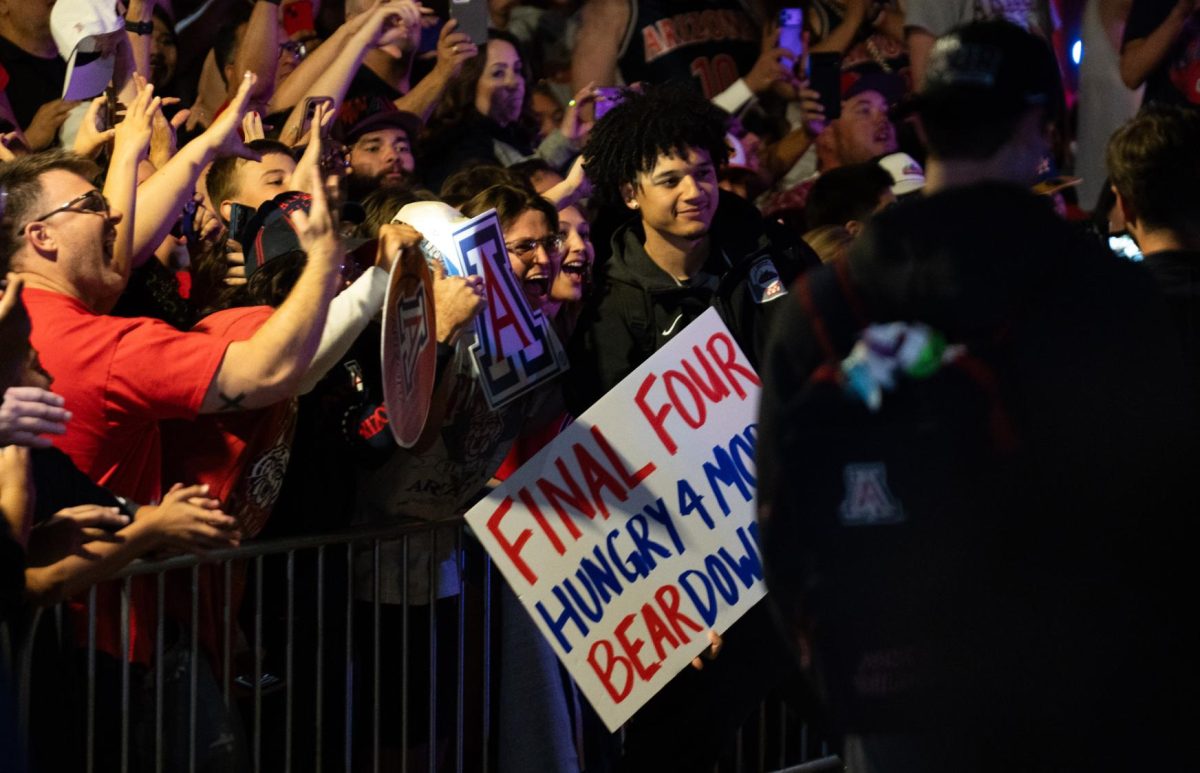 Brayden Burries poses with fans early Sunday morning outside McKale Center after flying back from Arizona's Elite 8 win against Purdue on March 28.