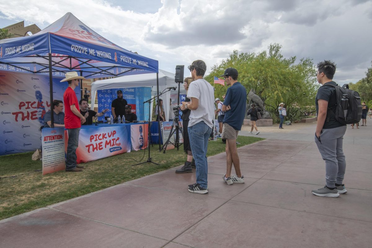 Students gather and listen during a Turning Point USA “Pick Up the Mic” event at the University of Arizona on March 31.