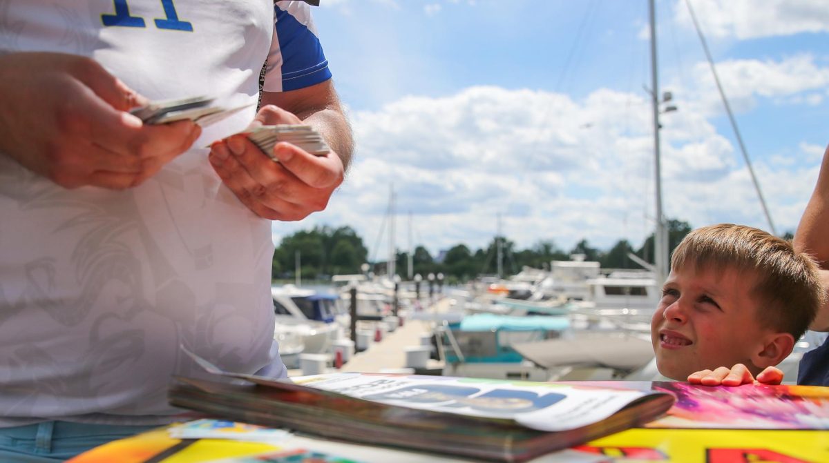 Nicolas looks to a fellow collector, Z is what he referred to himself as, while they conduct a trade of stickers on The Wharf in Washington D.C. before the USA vs Australia match on June 19.