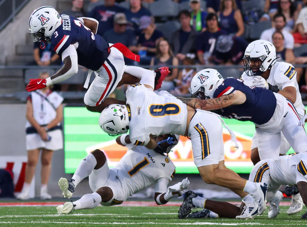 Kedrick Reescano attempts to hurdle NAU defenders at Casino Del Sol Stadium on Sept. 5.