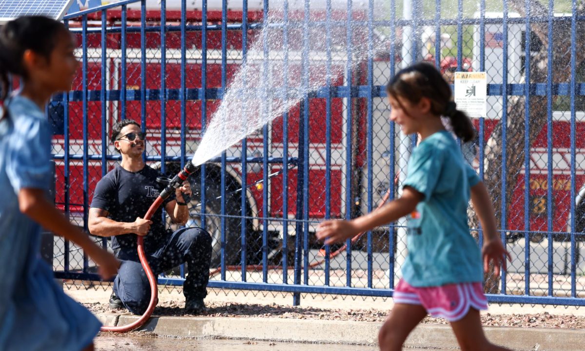 A Tucson firefighter sprays fans leaving Mulcahy Stadium following a warm match. The temperature peaked around 95 degrees fahrenheit during the match.
