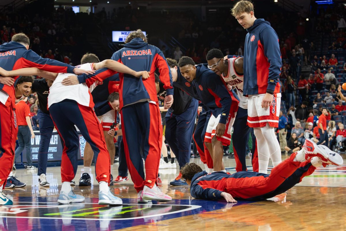 Joaquin Rigdon slides into the huddle after warm-ups in the exhibition game against San Francisco in McKale Center at ALKEME Arena on Oct. 13.