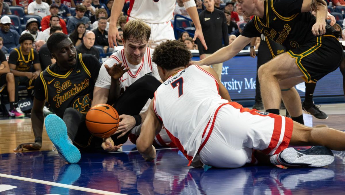 Motiejus Krivas and Derek Dixon scramble to regain possession of the ball in the second half of the exhibition game against San Francisco in McKale Center at ALKEME Arena on Oct. 13.