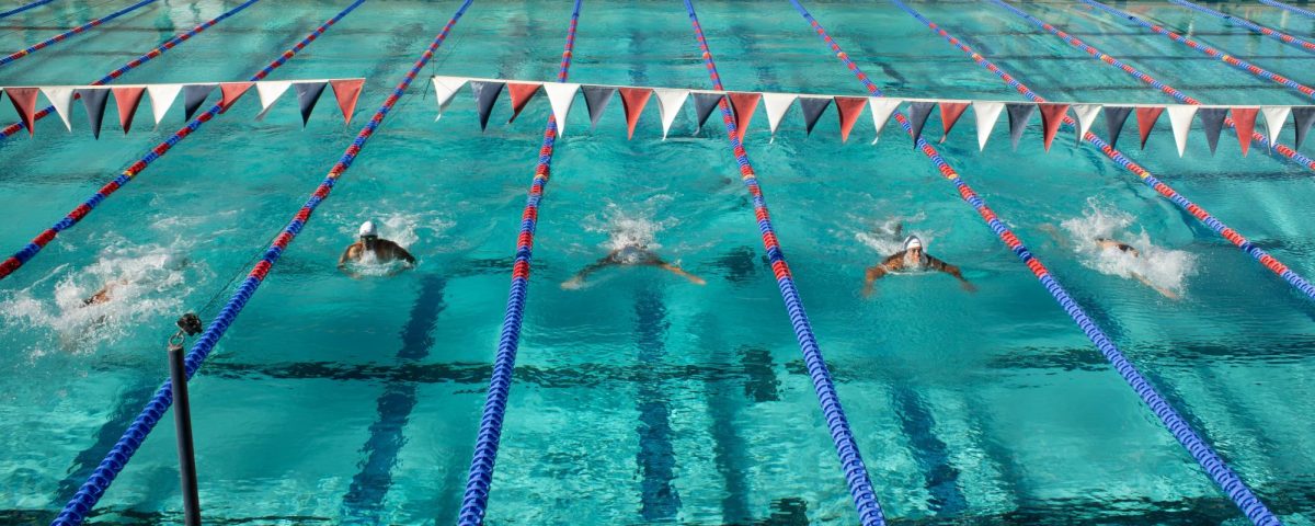 Ocean Morin in the far left lane takes the lead during the mens 100 yeard breastroke during the Red v. Blue intrasquad meet at the Hillenbrand Aquatic Center of Oct. 2.