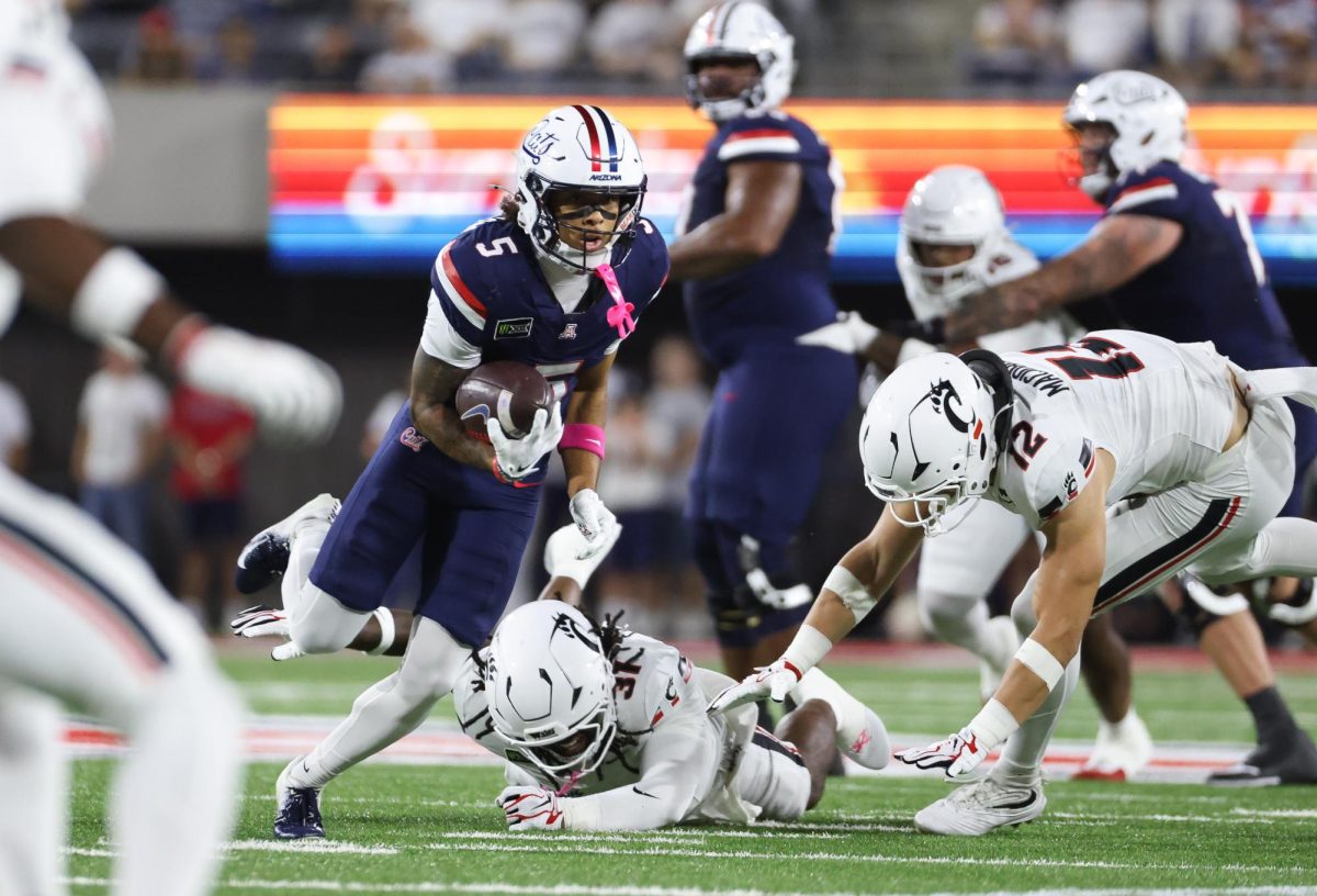 Giovanni Richardson breaks past two tacklers to pick up yardage against Cincinnati on Oct. 3 at Casino Del Sol Stadium.
